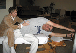 Photo: Leslie E. Frank assisting patient in a side bend exercise on the GyrotoniC HANDLE UNIT. 